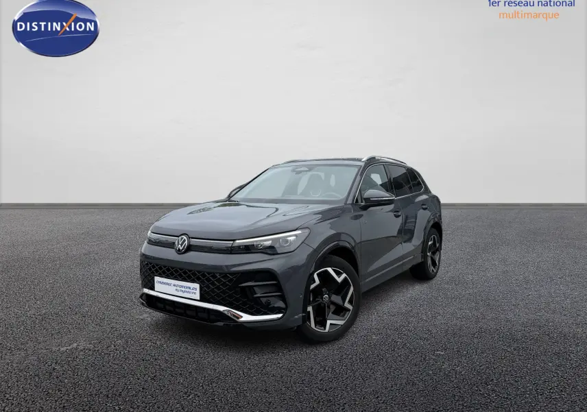 Volkswagen Tiguan gris en 3/4 avant droit avec jantes alliage et calandre noire distinctive R-Line.