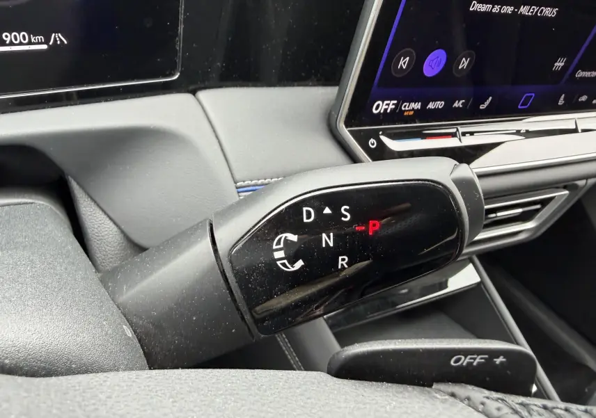 Gros plan sur le levier de vitesses DSG7 noir du Volkswagen Tiguan gris, avec écran tactile et tableau de bord partiel visible.