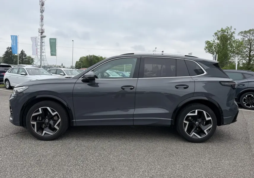 Vue de profil côté gauche d'un Volkswagen Tiguan gris 2025 avec jantes alliage 19 pouces et vitres teintées.
