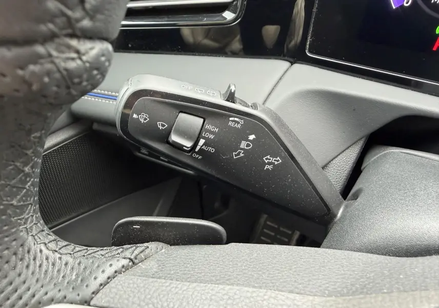 Gros plan sur la manette de commande des essuie-glaces et clignotants du Volkswagen Tiguan 2025, intérieur noir.