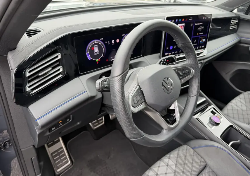 Intérieur du Volkswagen Tiguan 2025 vue côté conducteur, volant cuir sport et tableau de bord digital polychrome.