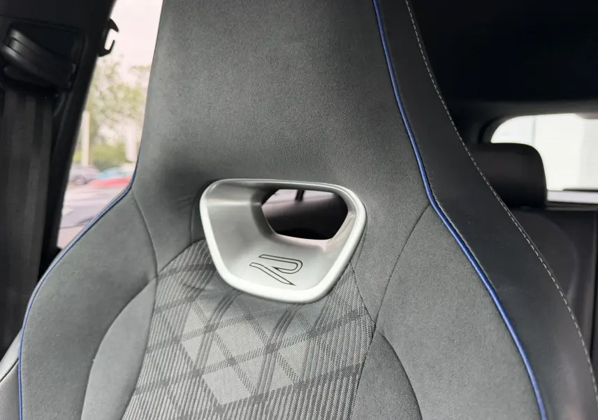 Gros plan sur le siège avant sport gris avec surpiqûres bleues et logo R du Volkswagen Tiguan 2025.