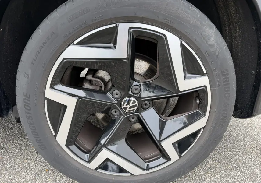 Gros plan sur la jante alliage 19 pouces bicolore noire et argentée du Volkswagen Tiguan gris, avec logo VW central.