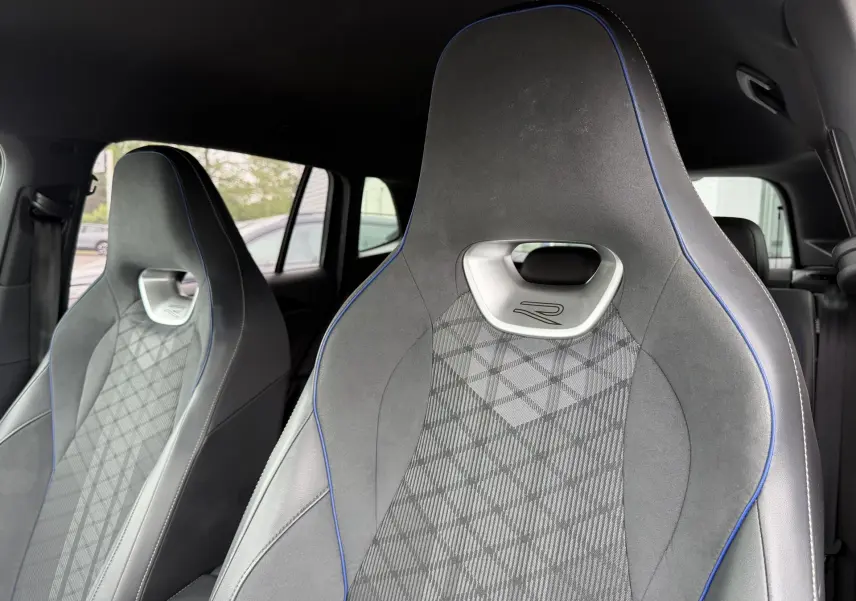 Gros plan sur les sièges avant sport gris avec surpiqûres bleues et logo R du Volkswagen Tiguan 2025.