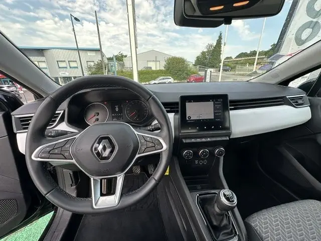Vue intérieure avant de la Renault Clio noire 2022, montrant le volant multifonction, tableau de bord et levier de boîte manuelle.
