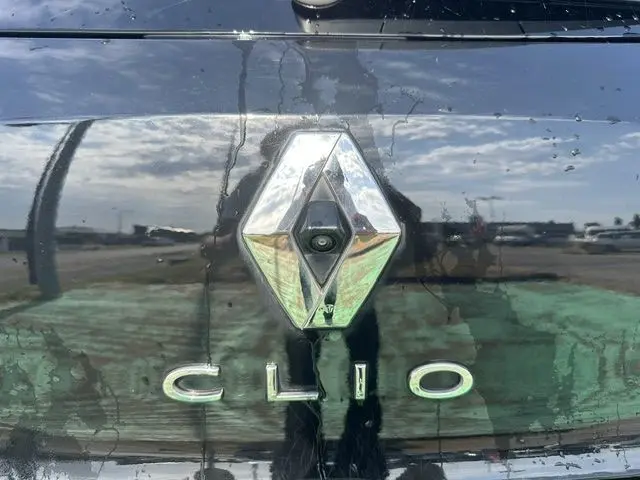 Gros plan sur le logo Renault et le badge Clio sur la malle arrière noire d'une Renault Clio 2022.