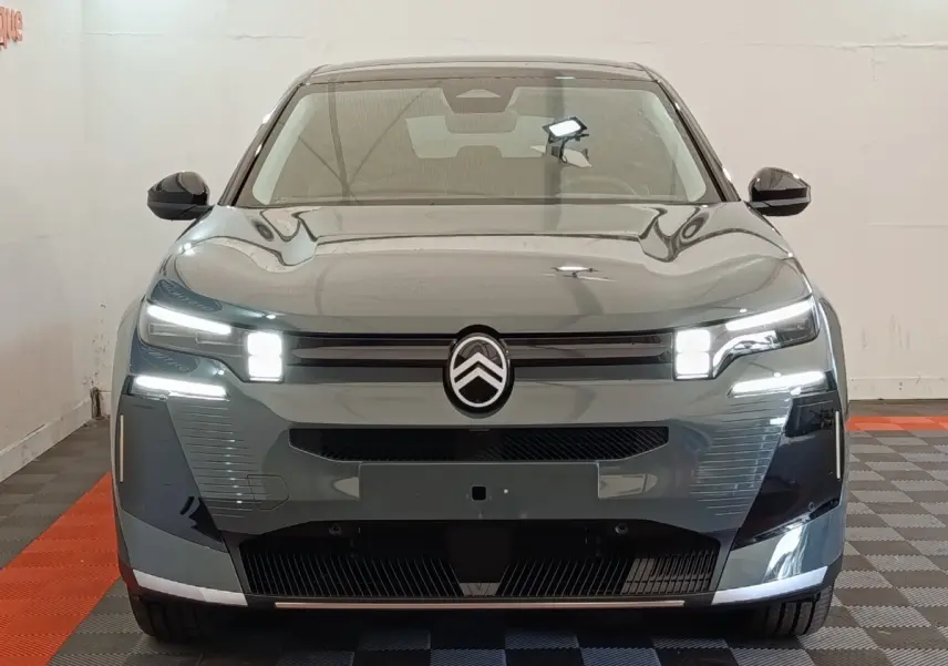 Vue frontale d'une Citroën C5 hybride 145ch auto MAX verte avec feux LED allumés et logo Citroën central.