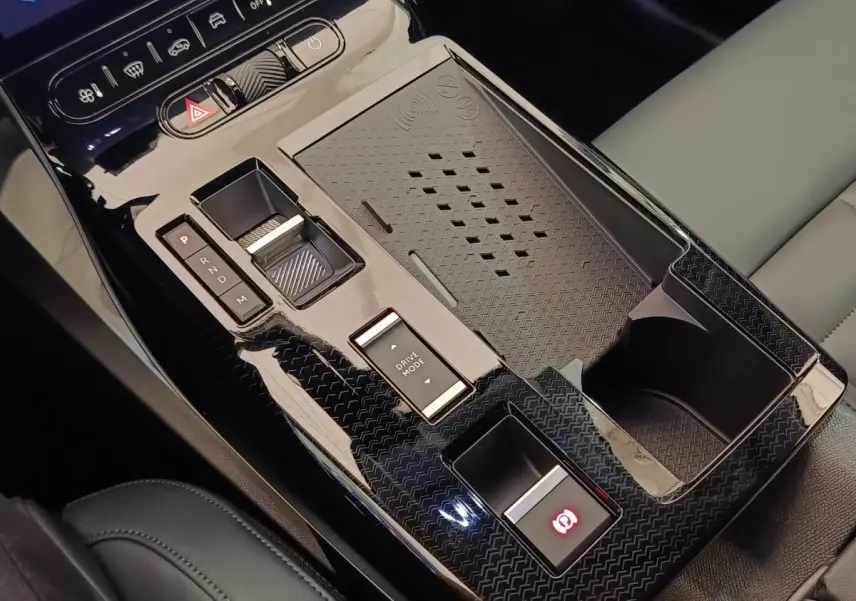 Gros plan sur la console centrale noire brillante du Citroën C5 Hybride 2026 avec commandes de boîte auto et recharge sans fil.