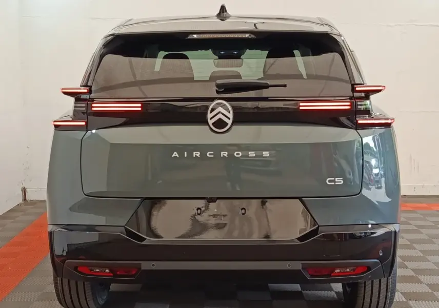 Vue arrière d'un Citroën C5 Aircross hybride vert avec feux arrière LED horizontaux et toit noir brillant.