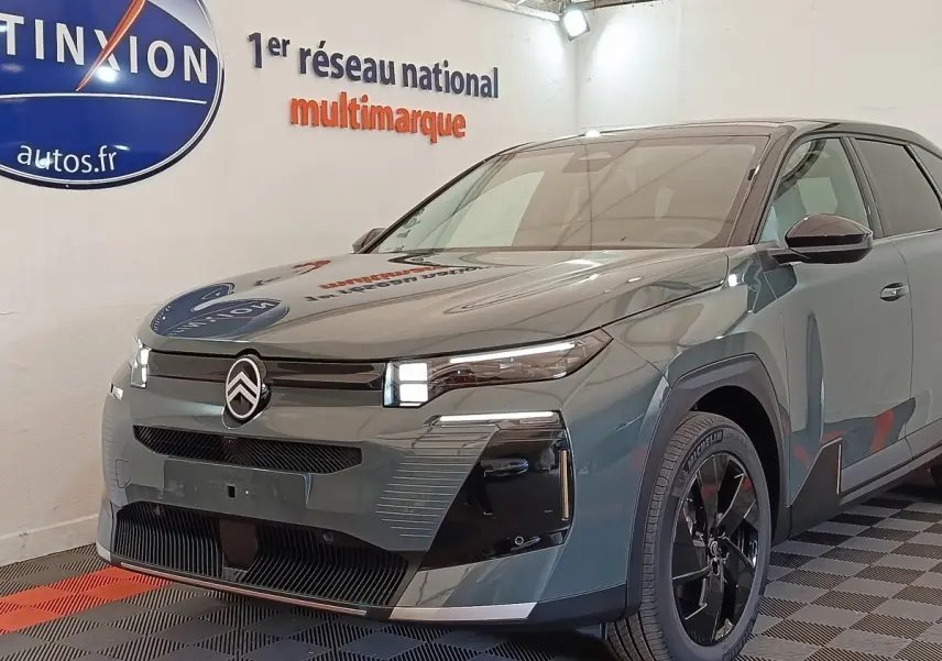 Vue 3/4 avant droit d'une Citroën C5 hybride verte avec calandre noire et jantes noires brillantes.