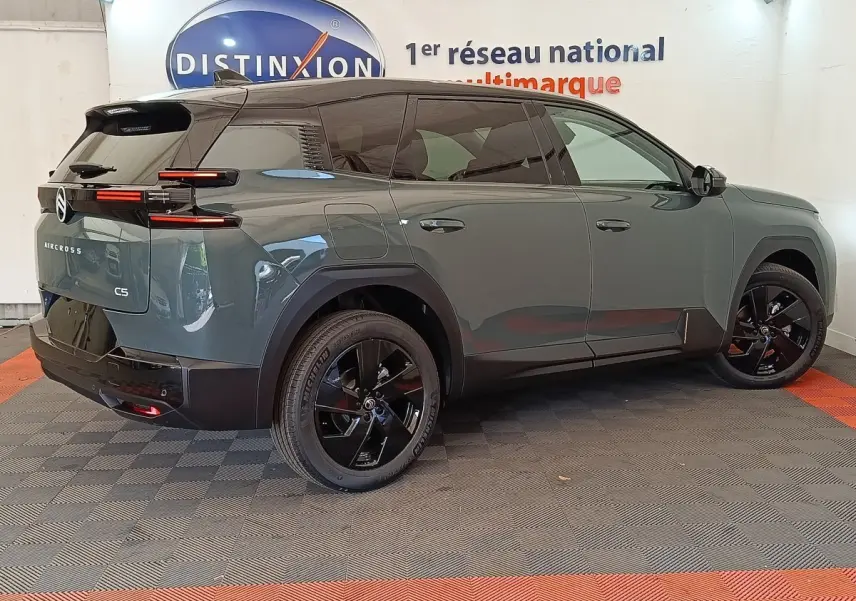 Vue 3/4 arrière droite d'un Citroën C5 Aircross hybride vert avec jantes noires et feux arrière LED distinctifs.