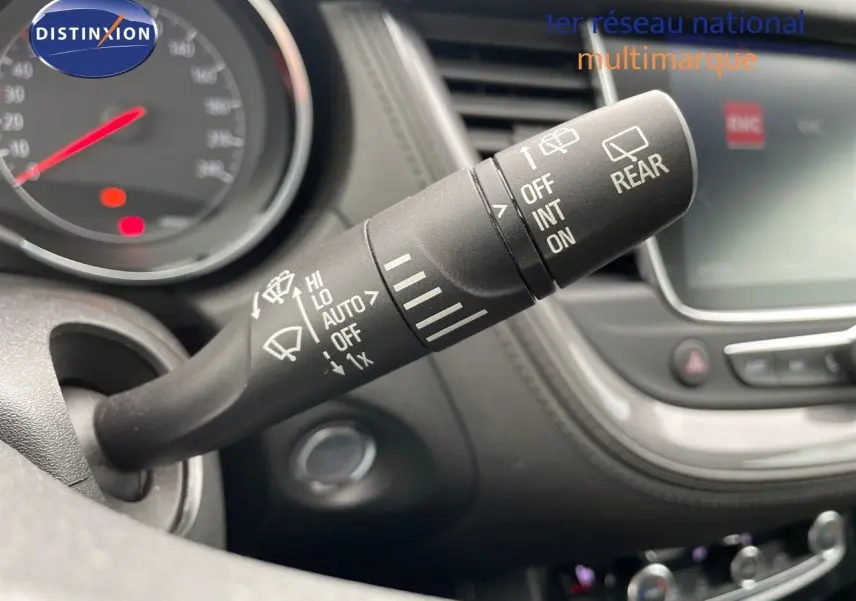 Le levier de commande des essuie-glaces dans l'habitacle de l'Opel Grandland X, avec tableau de bord et écran tactile en arrière-plan.