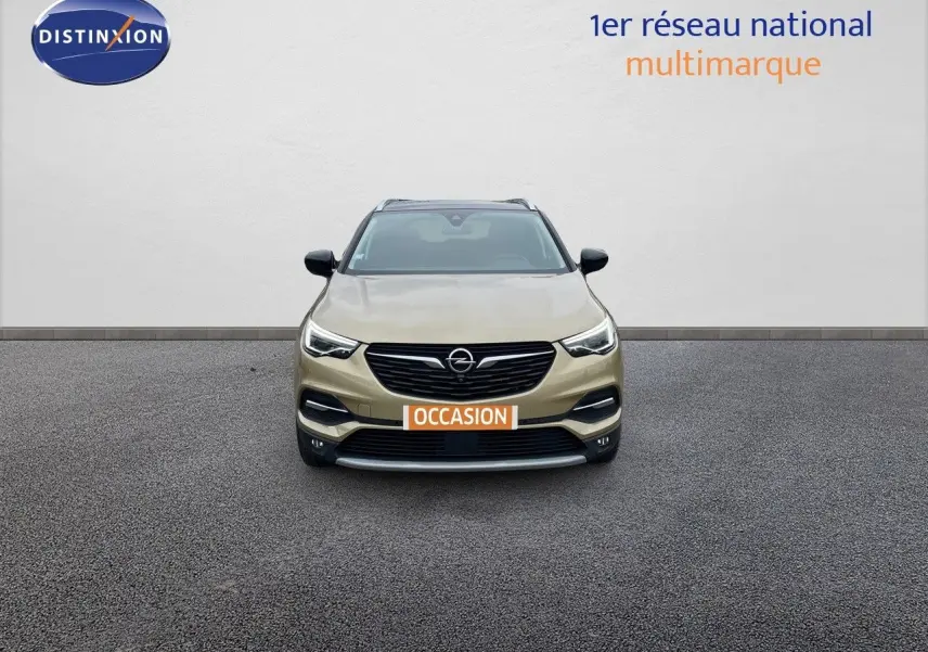 Vue frontale d'un Opel Grandland X 2018 couleur Golden Sunstone Metal avec plaque "OCCASION" sur un sol gris.