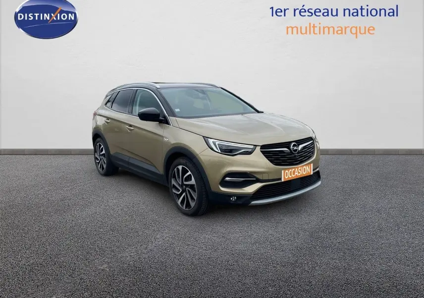 Opel Grandland X doré vu en 3/4 avant droit, avec jantes bi-ton et calandre noire distinctive.