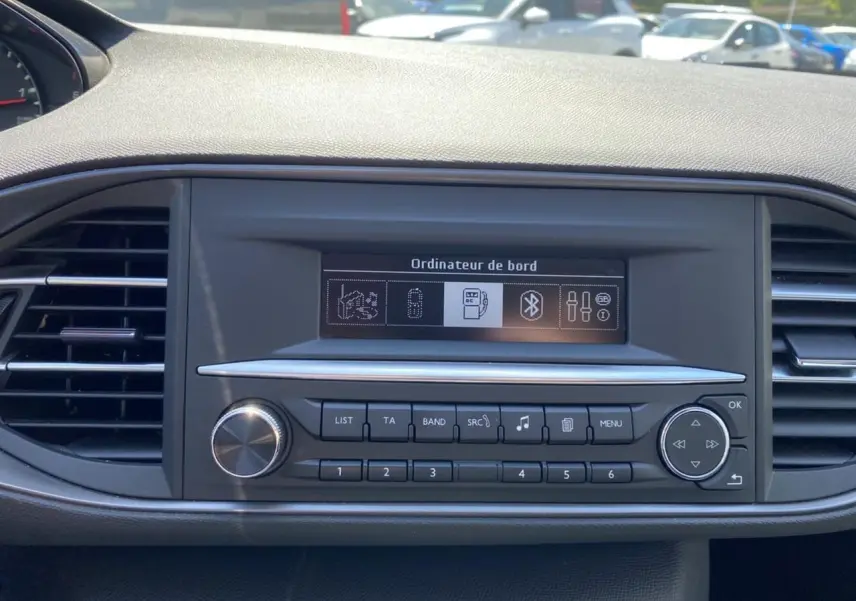 Tableau de bord de Peugeot 308 SW 2017 avec écran ordinateur de bord et commandes audio visibles en gros plan.