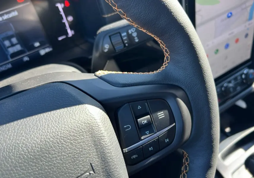 Gros plan sur le volant avec commandes intégrées et coutures contrastées du Ford Ranger 2025 Wildtrak Bleu Lightning.