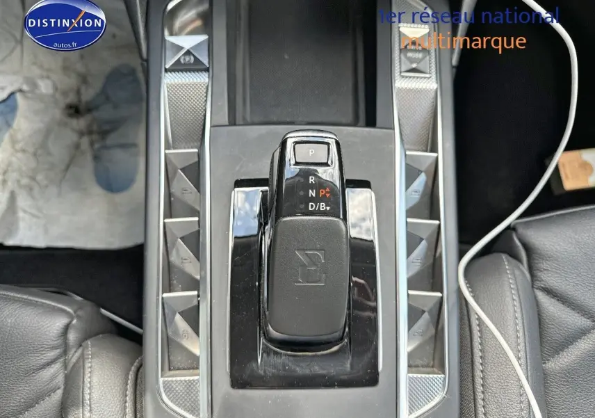 Gros plan sur la console centrale du DS3 Crossback E-TENSE 2021, avec levier de vitesses automatique et cuir noir.
