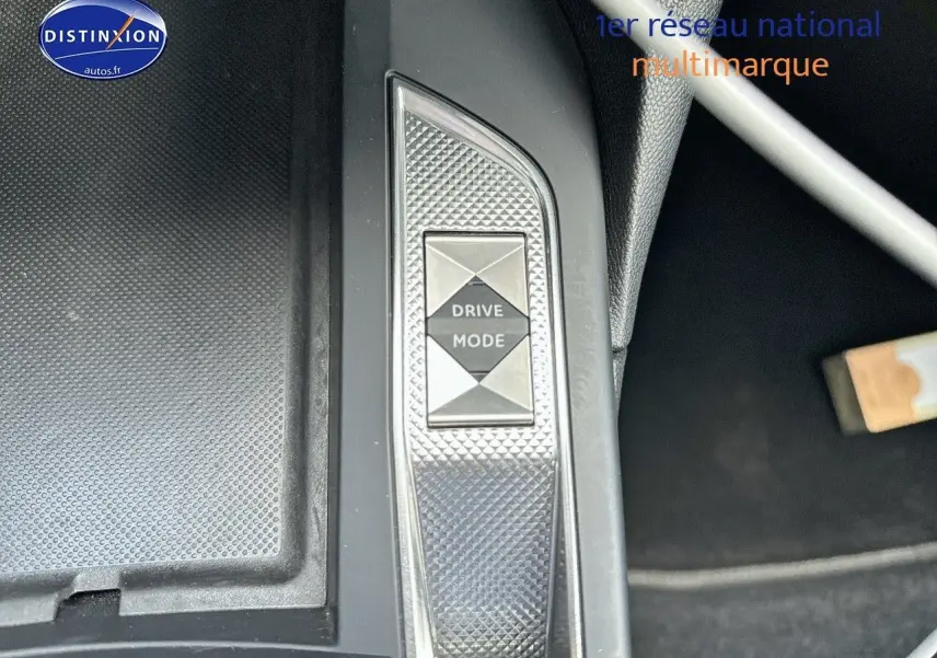 Gros plan sur le bouton Drive Mode de la console centrale du DS3 Crossback E-TENSE noir métal, intérieur moderne.