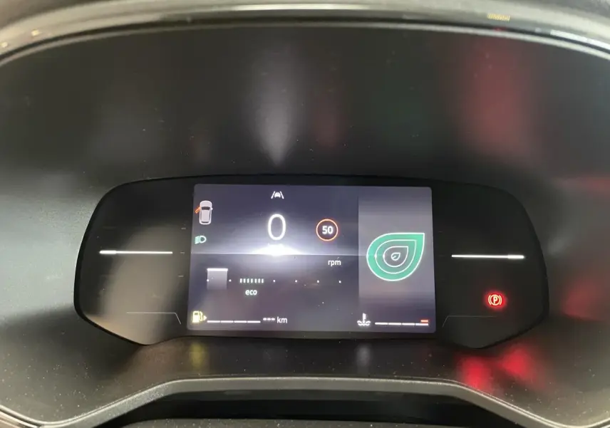Tableau de bord numérique de Renault Clio 1.5 Blue dCi 2025 affichant vitesse, mode éco et alertes, vue frontale rapprochée.