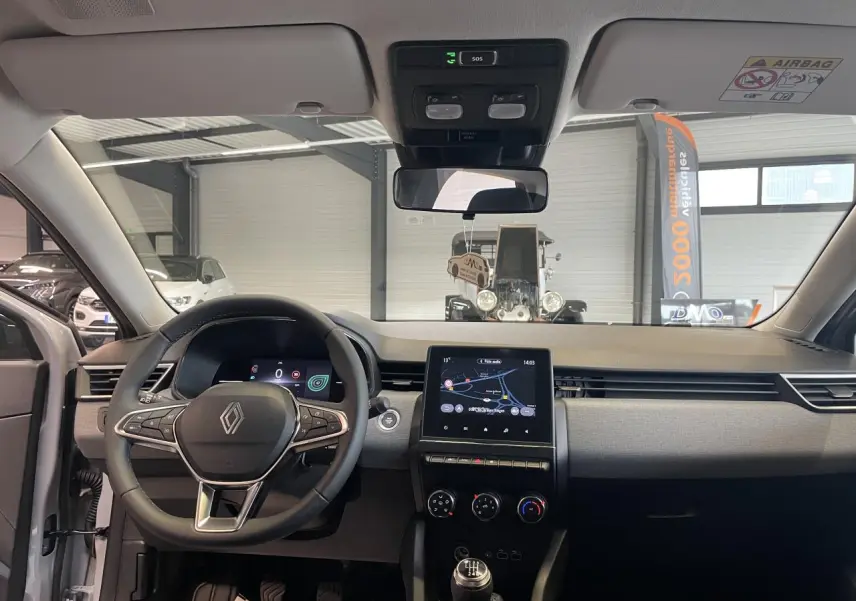 Vue intérieure avant de la Renault Clio 2025 avec tableau de bord moderne et écran tactile de navigation 7 pouces.