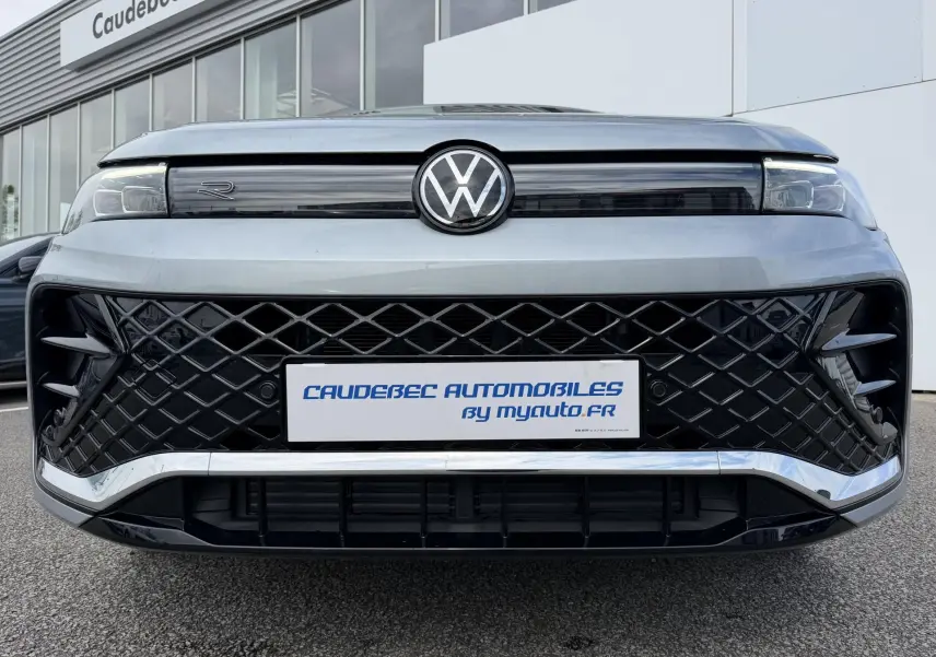 Vue frontale rapprochée du Volkswagen Tiguan gris 2025 avec calandre noire à motif losange et logo VW central.