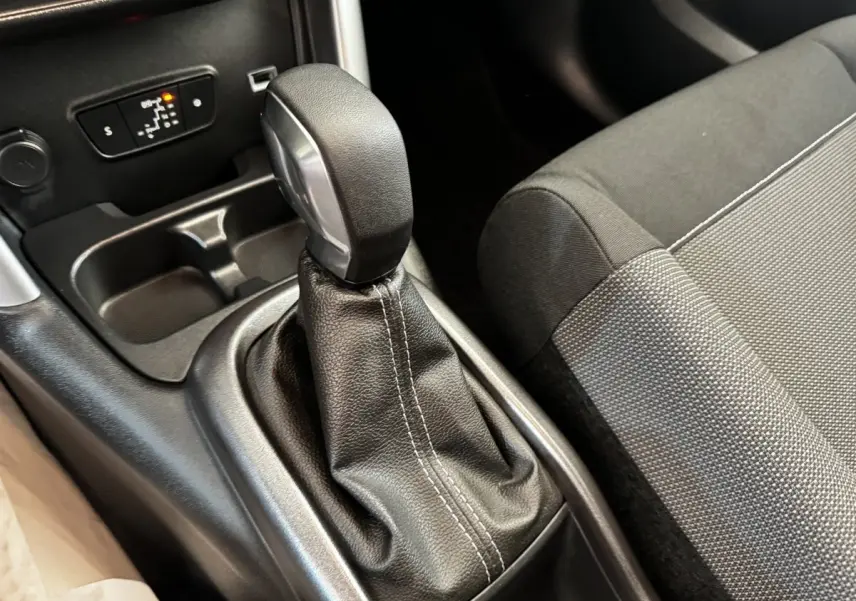 Gros plan sur le levier de vitesses automatique en cuir noir et la console centrale de la Citroën C3 gris foncé.