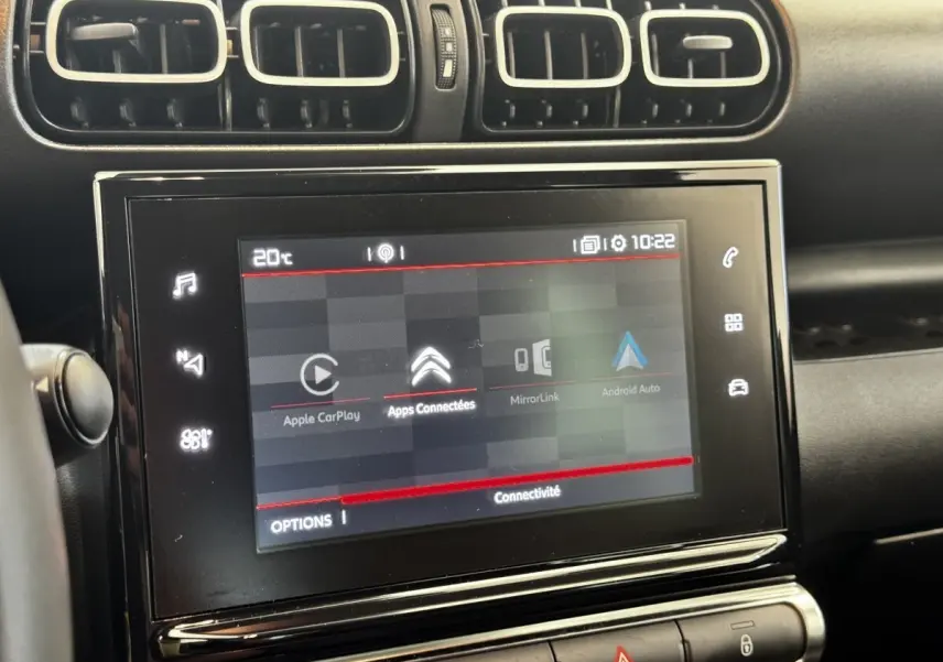 Écran tactile central de 7 pouces dans l’habitacle gris foncé d’une Citroën C3 PureTech 110 Shine, avec commandes autour.