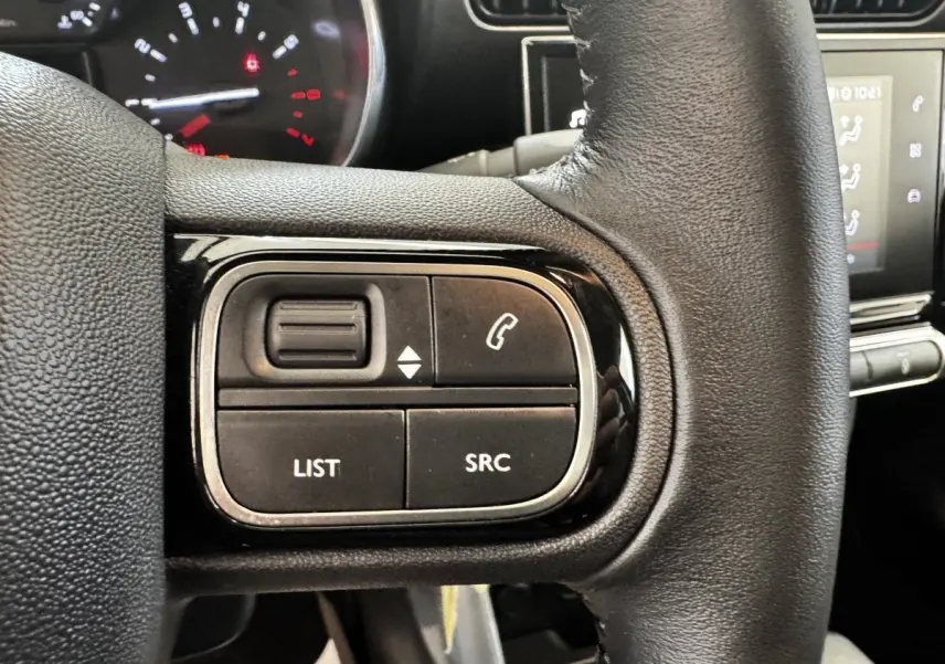 Gros plan sur le volant cuir noir de la Citroën C3 2019 avec commandes multifonctions et tableau de bord partiellement visible.
