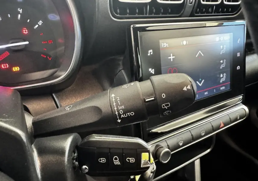 Gros plan sur la commande d’essuie-glace et l’écran tactile central du tableau de bord de la Citroën C3 2019.