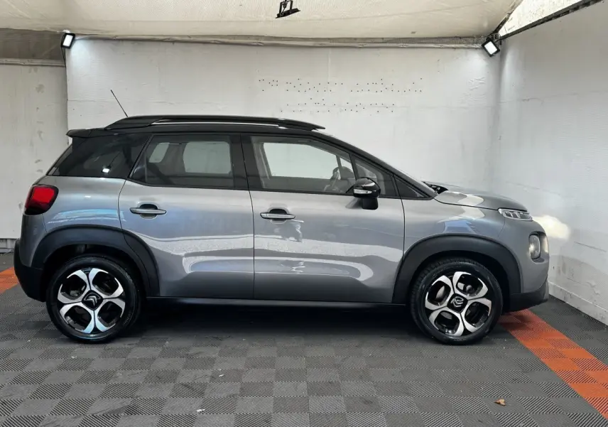 Profil droit d'une Citroën C3 gris foncé 2019 avec toit noir et jantes alliage distinctives en intérieur neutre.