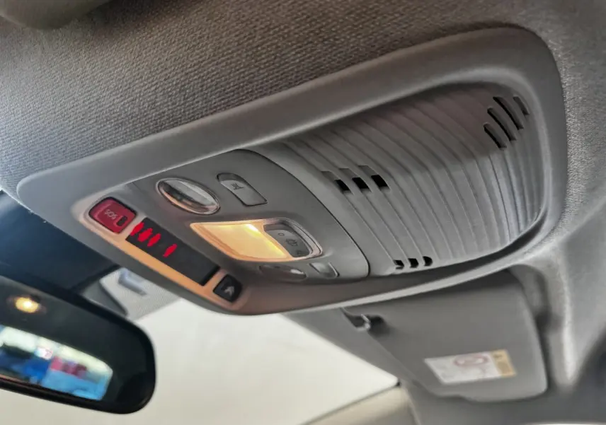 Vue intérieure en contre-plongée du plafonnier gris avec éclairage et boutons SOS dans une Citroën C3 gris foncé de 2019.