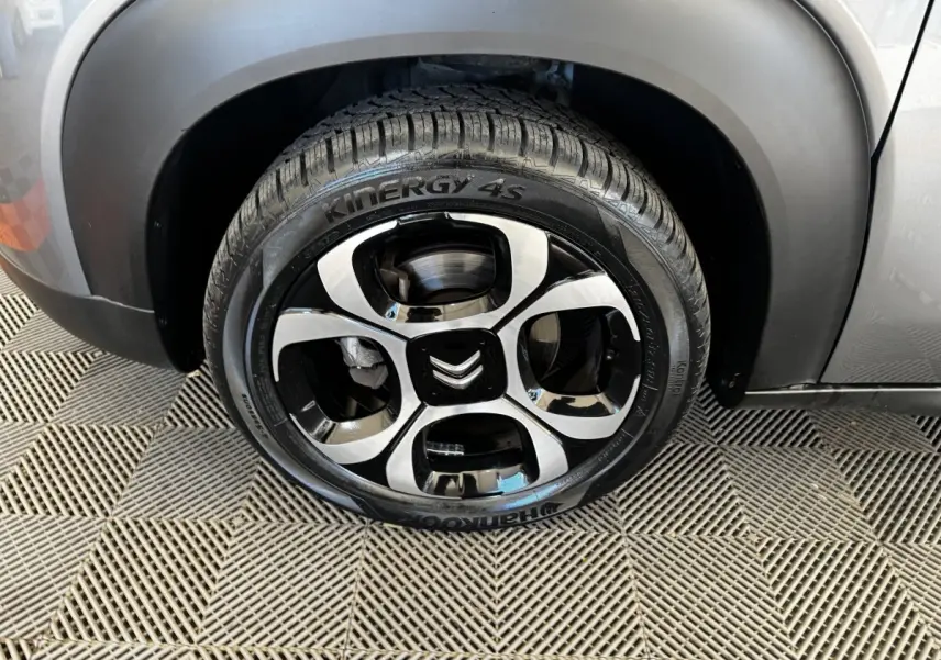Gros plan sur la roue avant droite gris foncé d'une Citroën C3 2019 avec jante noire et argentée au design distinctif.