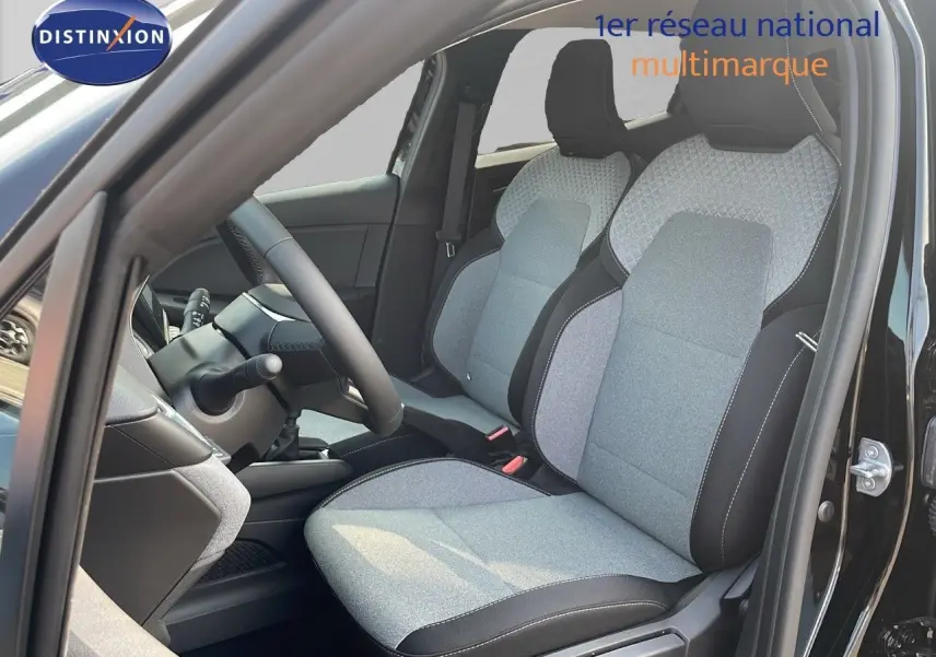 Vue intérieure côté conducteur de la Renault Clio 2025 noire étoile métal, sièges tissu gris clair avec surpiqûres noires.