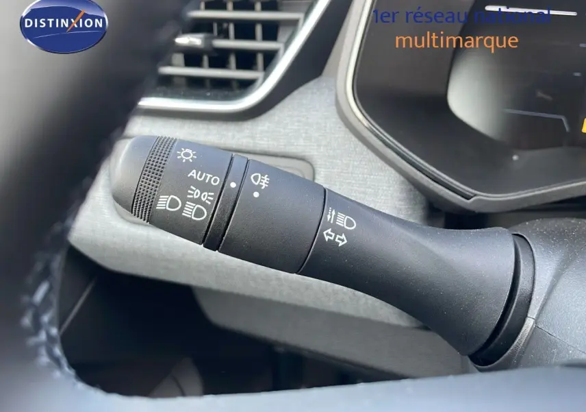 Gros plan sur la commande des feux et clignotants dans l'habitacle gris d'une Renault Clio noire étoile métal 2025.