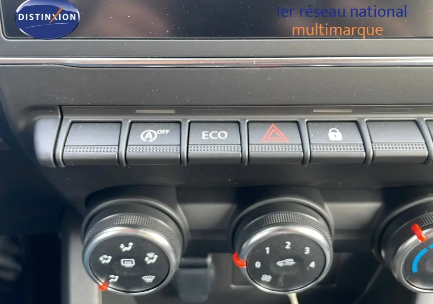Gros plan sur les commandes de climatisation et boutons fonctionnels du tableau de bord de la Renault Clio noire étoile métal 2025.