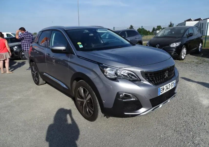 Peugeot 3008 gris Artense en 3/4 avant droit, avec barres de toit aluminium et jantes noires distinctives.