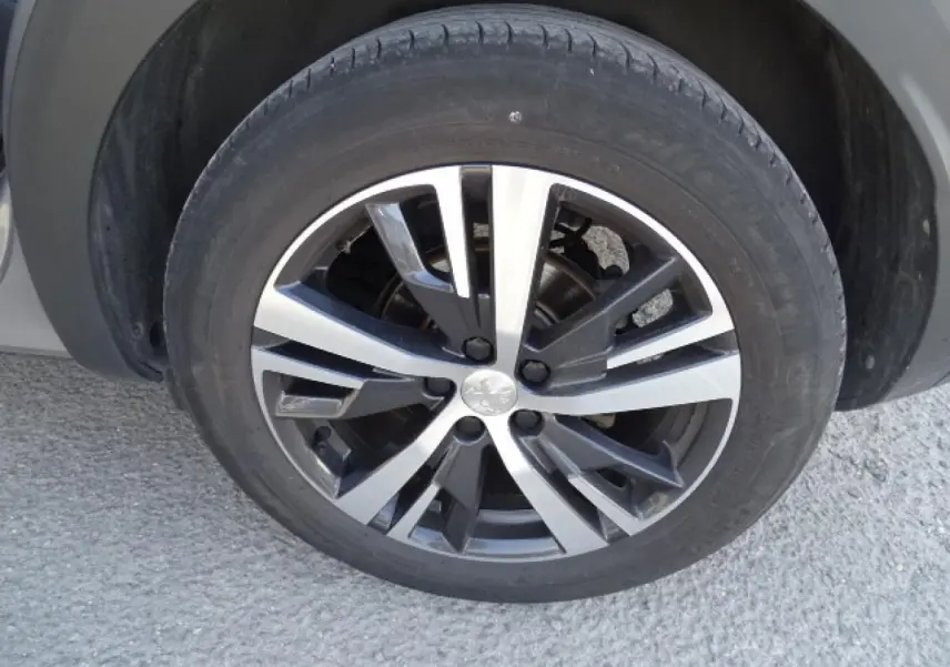 Gros plan sur la roue de secours galette avec jante alliage bicolore du Peugeot 3008 gris Artense 2017.