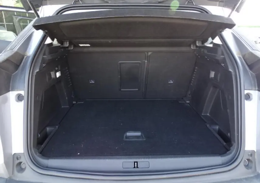 Coffre ouvert du Peugeot 3008 gris Artense, vue arrière montrant l'espace de chargement vide et la tablette de couverture relevée.