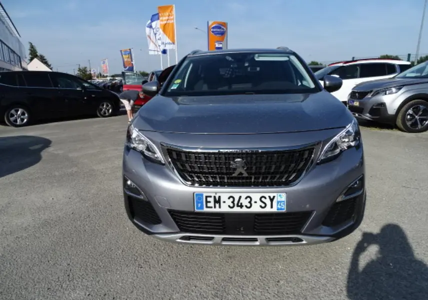 Vue frontale d'un Peugeot 3008 gris Artense avec calandre noire et plaques d'immatriculation françaises visibles.