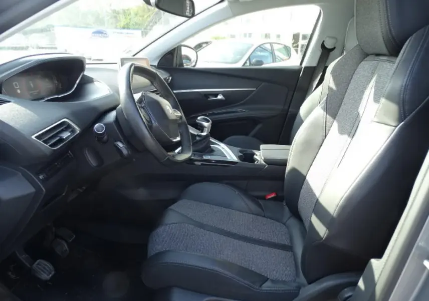 Intérieur du Peugeot 3008 2017 vu côté conducteur, sièges tissu et cuir noirs avec tableau de bord moderne.