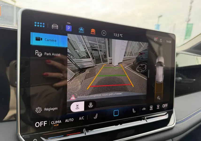 Écran tactile intérieur du Volkswagen Tiguan gris montrant l'affichage caméra de recul avec guidage Park Assist.