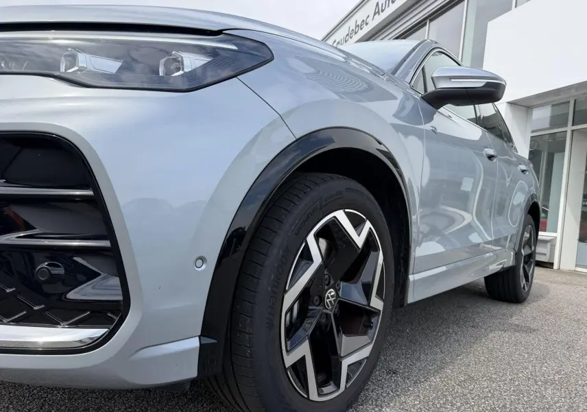 Vue en gros plan sur l'avant droit gris métallisé du Volkswagen Tiguan 2025 avec jante alliage distinctive.