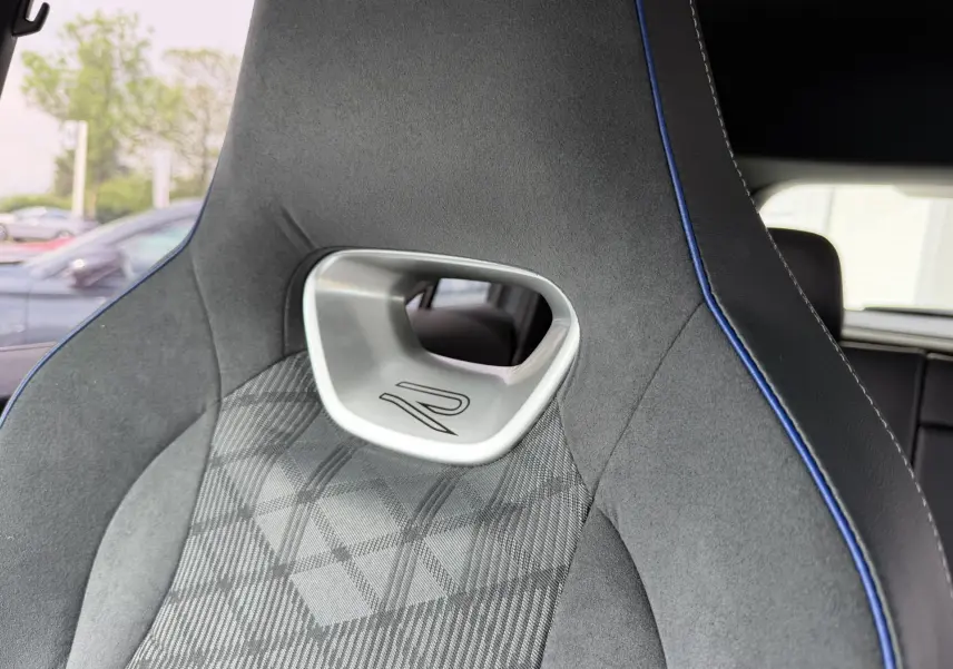 Gros plan sur le siège avant sport gris avec surpiqûres bleues et logo R du Volkswagen Tiguan 2025.