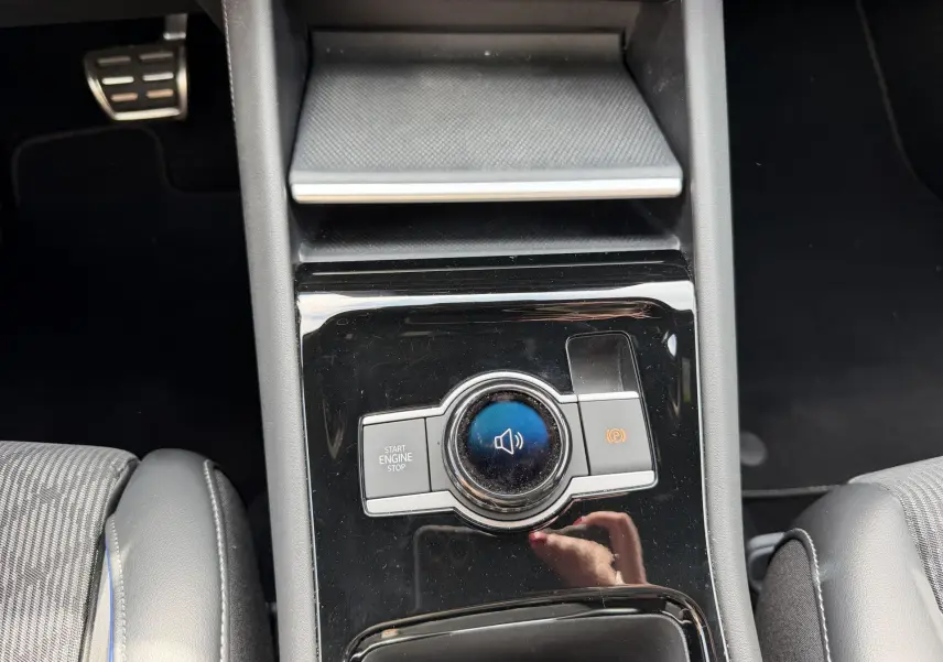 Gros plan sur la console centrale noire du Volkswagen Tiguan 2025 avec bouton Start/Stop et frein à main électronique.