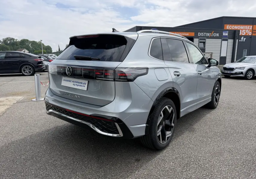 Volkswagen Tiguan gris métallisé vu en 3/4 arrière droit, avec jantes alliage 19 pouces et feux arrière LED.