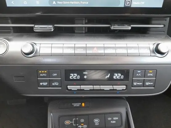Vue rapprochée du tableau de bord du Hyundai Kona 2024, montrant les commandes de climatisation et multimédia en finition Intuitive.