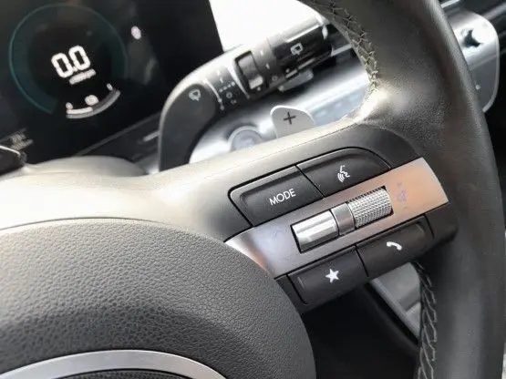 Gros plan sur les commandes multifonctions noires et argentées du volant du Hyundai Kona 2024, intérieur noir.