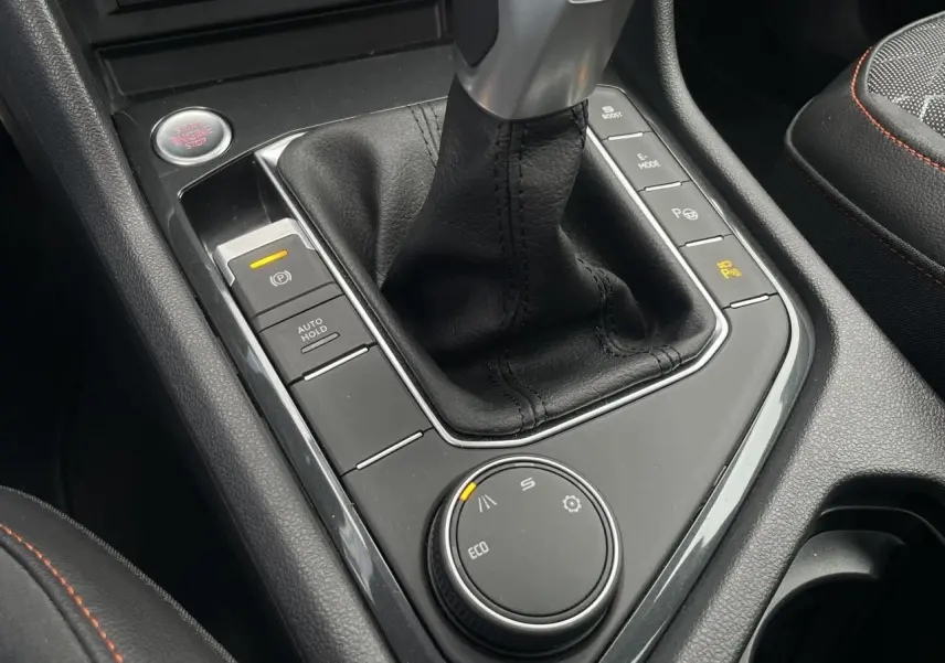 Gros plan sur la console centrale du SEAT Tarraco gris Dauphin, avec levier de vitesses cuir et molette de modes de conduite.