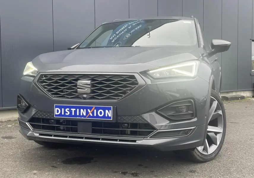 Vue avant rapprochée du SEAT Tarraco gris dauphin avec phares LED allumés et jantes alliage 20 pouces côté droit visible.