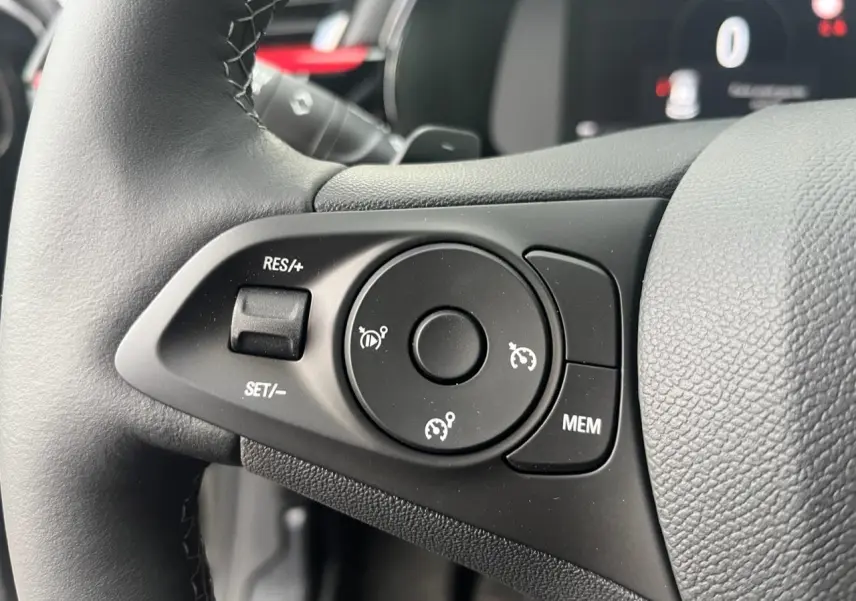 Gros plan sur les commandes du régulateur de vitesse au volant multifonction noir de l'Opel Corsa GS Line 2022.